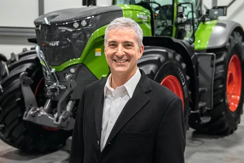 Eric Hansotia (President, Chairman and CEO AGCO Corporation) in front of a green Fendt tractor