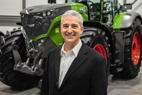 Eric Hansotia (President, Chairman and CEO AGCO Corporation) in front of a green Fendt tractor