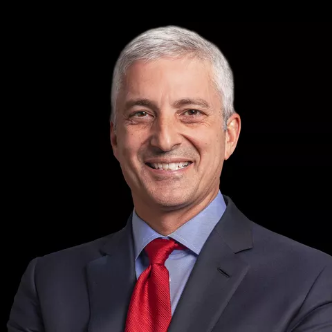 Portrait of Eric Hansotia (President, Chairman and CEO AGCO Corporation) wearing a blue suit and red tie