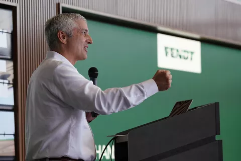 Eric Hansotia (President, Chairman and CEO AGCO Corporation) photographed while speaking from a podium in Jackson