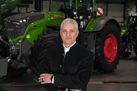 Eric Hansotia (President, Chairman and CEO AGCO Corporation) in front of a green Fendt tractor