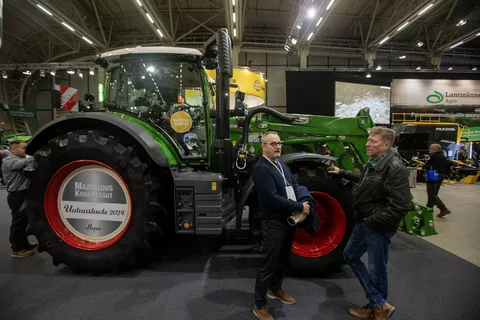 Two trade fair visitors standing in front of the award-winning Fendt 600 Vario and chatting