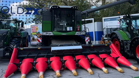 A Fendt straw walker combine harvester with red corn header