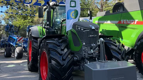 A Fendt tractor photographed from the front, with a Fendt combine harvester to the right
