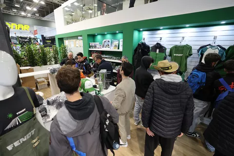 Visitors and fans in the Fendt merchandise area buy Fendt clothing and caps