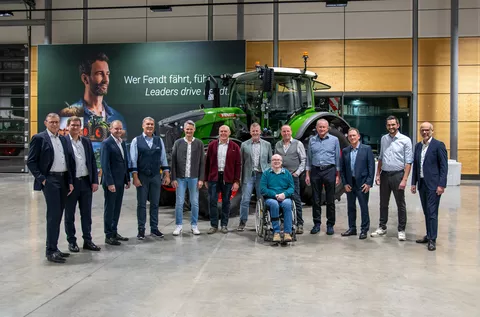 Fendt employees celebrating 40 years with the company and Fendt management in front of a Fendt tractor