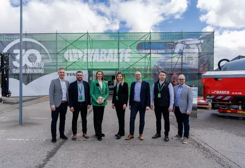 7 people, women in the centre, a woman with a green jacket holds a prize in her hand, in front of an Ivabalté logo