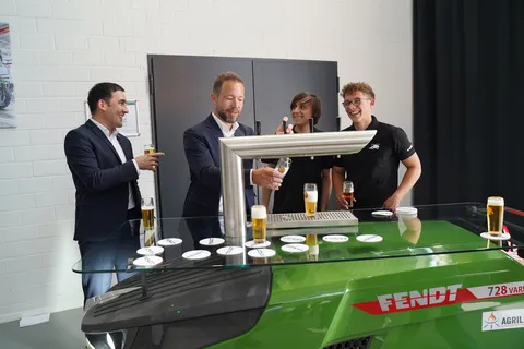 Four men, two of whom are apprentices (right), stand behind the drinks dispenser and laugh while one of them pours himself a cold drink
