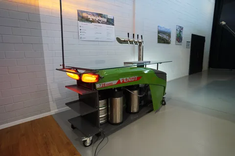 Fendt dispensing station (diagonally from behind) with Fendt logo, glass shelf, glass racks and front and rear lights switched on.