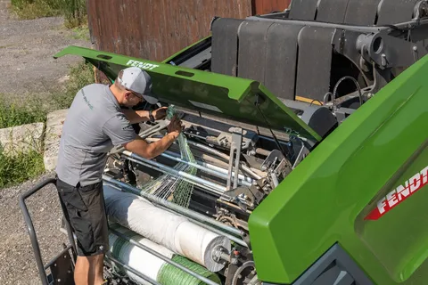 A quick-change system for film and net rolls is visible under the open flap of the Fendt Rotana K Combi round baler.