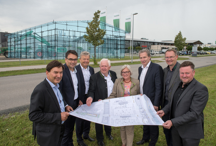 People with building plans in front of the future Fendt Forum