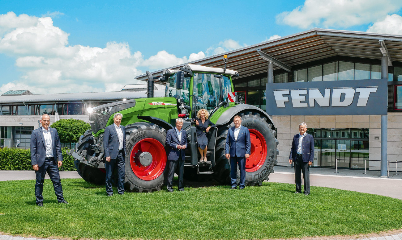 People standing in front of a Fendt tractor in front of the Fendt Forum in Marktoberdorf, Germany.