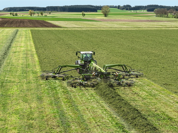 Fendt 500 Vario forms a swath in a field with a Fendt Former 4-rotor.