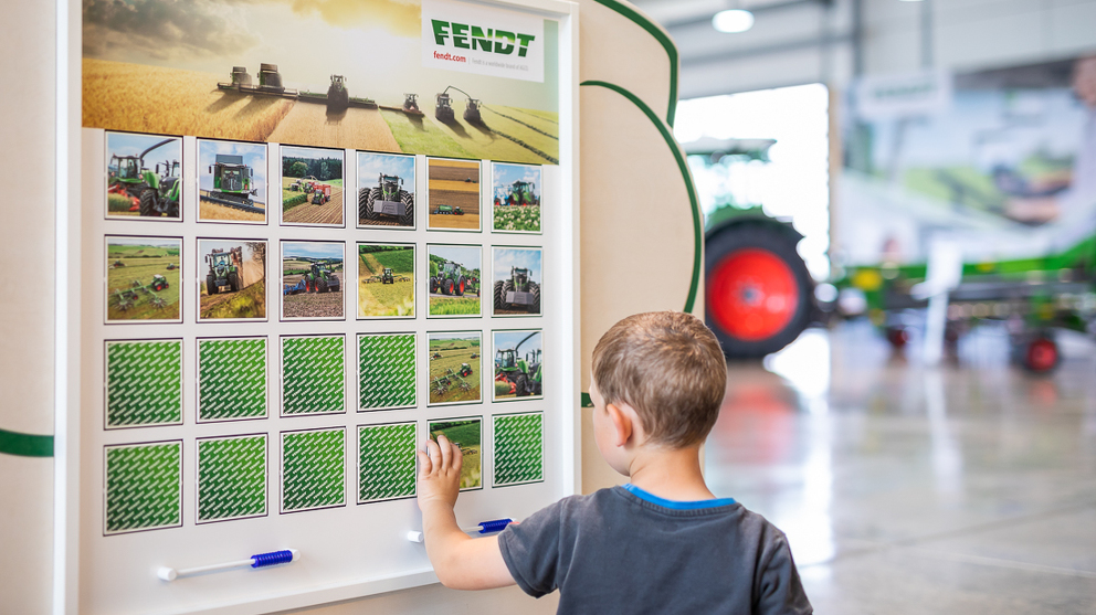 A boy is playing on a blackboard at the Fendt Forum.