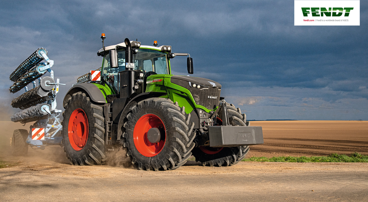 Fendt 1000 Vario with disc harrow on the road next to a field.
