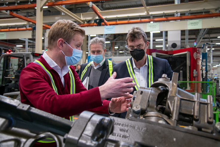 (ltr) Dr. Jan Cachay (Director, Manufacturing Transmissions Marktoberdorf) and Ekkehart Gläser explain the production of Fendt transmissions to Dr. Niels Pörksen