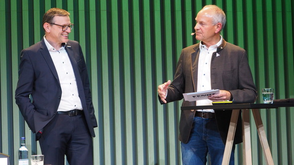 Walter Wagner and Sepp Nuscheler speak to each other on the stage