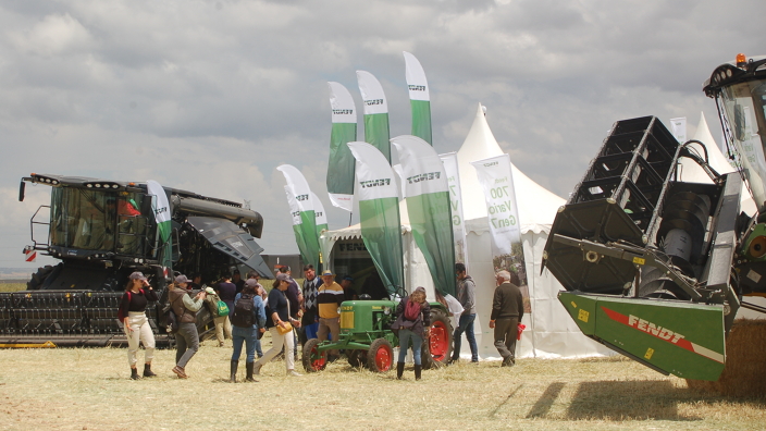 Fendt combine harvester surrounded by Fendt flags and visitors