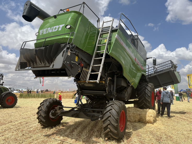 Fendt C-series straw walker combine for use on steep slopes, one tire on a bale of straw, inclined cutterbar