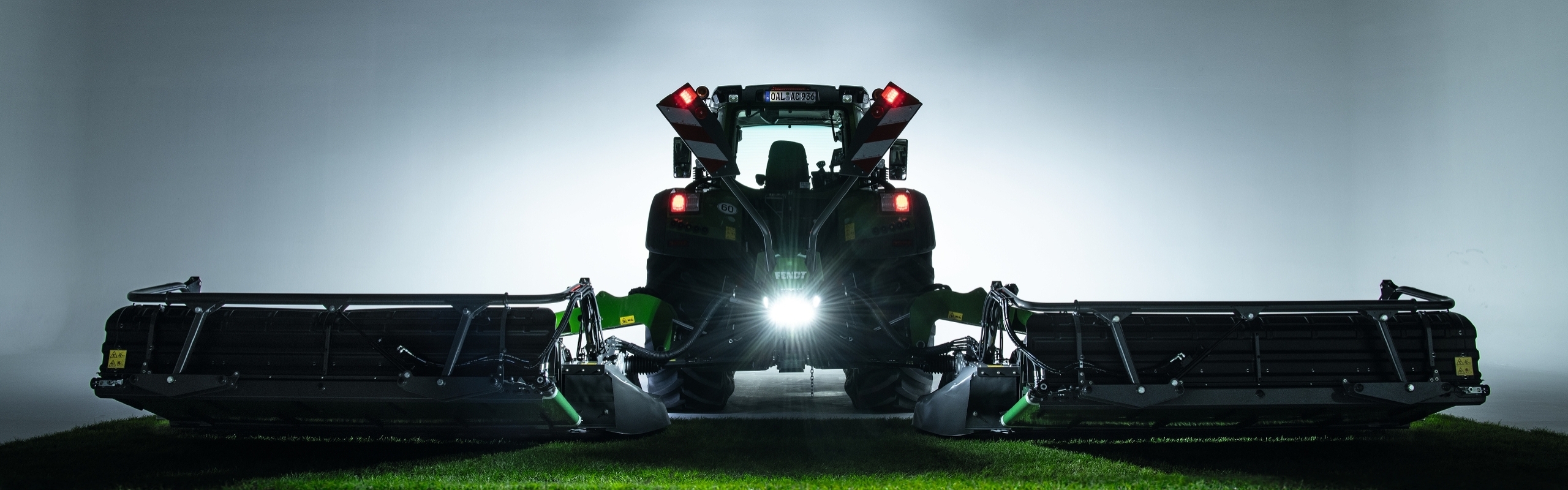 Fendt Slicer disc mowers A Fendt tractor with a Fendt Slicer disc mower standing in a field at dusk.