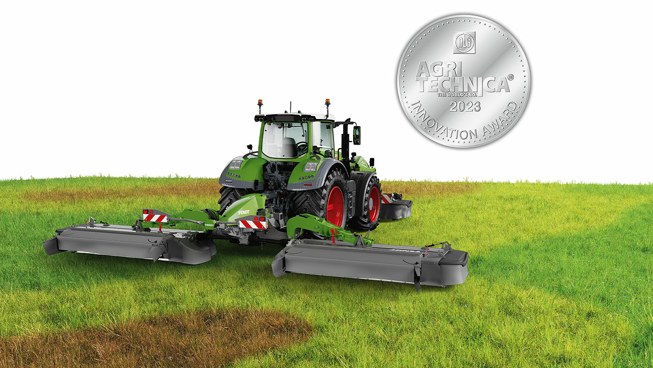 Fendt tractor in a meadow with the Fendt Slicer mower combination with "Innovation Award AGRITECHNICA" silver medal