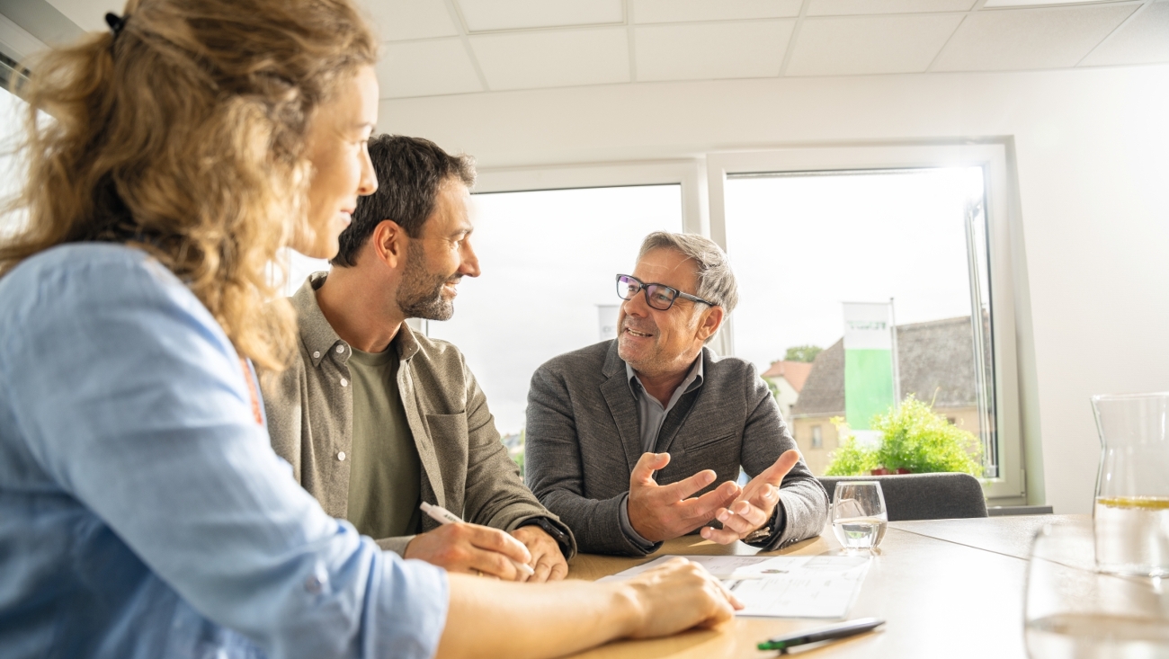 A female and male farmer sitting in the office with their Fendt dealer and receiving advice.