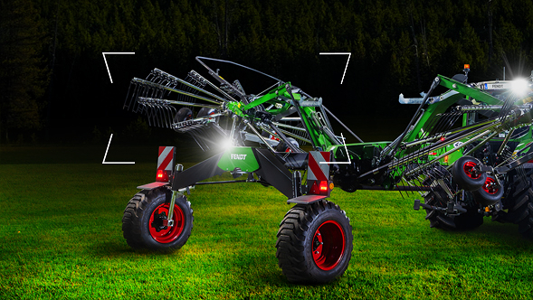 A Fendt Former stands in a meadow at dusk and is staged with lighting.