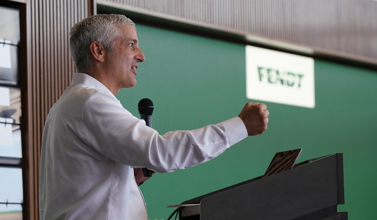 Eric Hansotia (President, Chairman and CEO AGCO Corporation) photographed while speaking from a podium in Jackson
