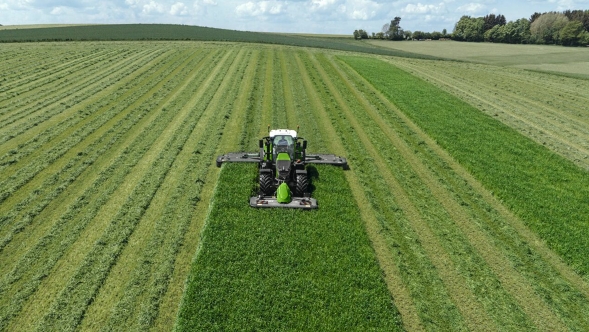 Fendt Slicer mower combination A farmer mows a green meadow with a Fendt Slicer mower combination.