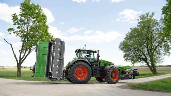 Transport position A green Fendt Vario Tractor on the street seen from behind with retracted arms