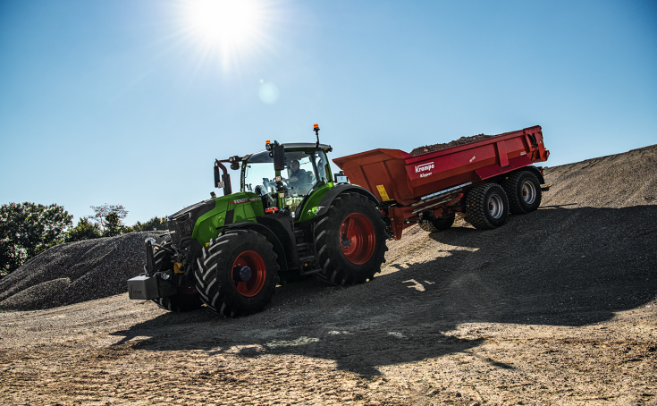 Fendt 728 Vario with Krampe tipping trailer A Fendt 728 Vario with a red Krampe tipper is driving down a hill on a construction site