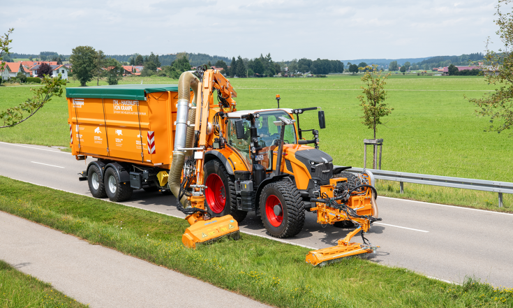 Fendt 728 Vario in municipal orange with a roadside arm carrying out mowing work Fendt 728 Vario in municipal orange with two roadside mowers mowing the roadside and with a trailer