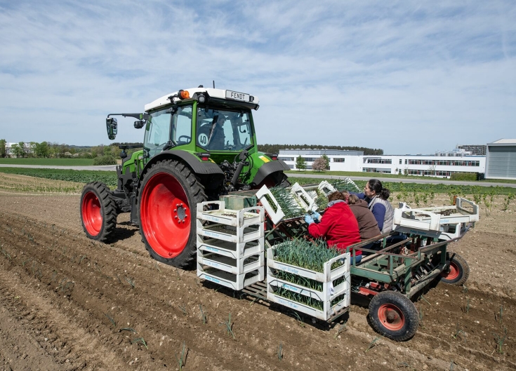 Fendt e107 Vario planting vegetable seedlings A Fendt e107 Vario with a vegetable planter loaded with vegetable boxes and planters at the back of the machine