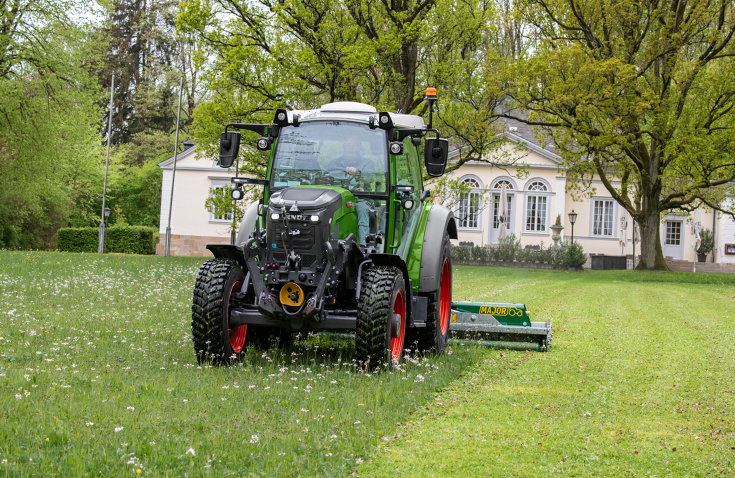Fendt e107 Vario during mowing work A Fendt e107 Vario mowing a meadow in a park in front of a historic building