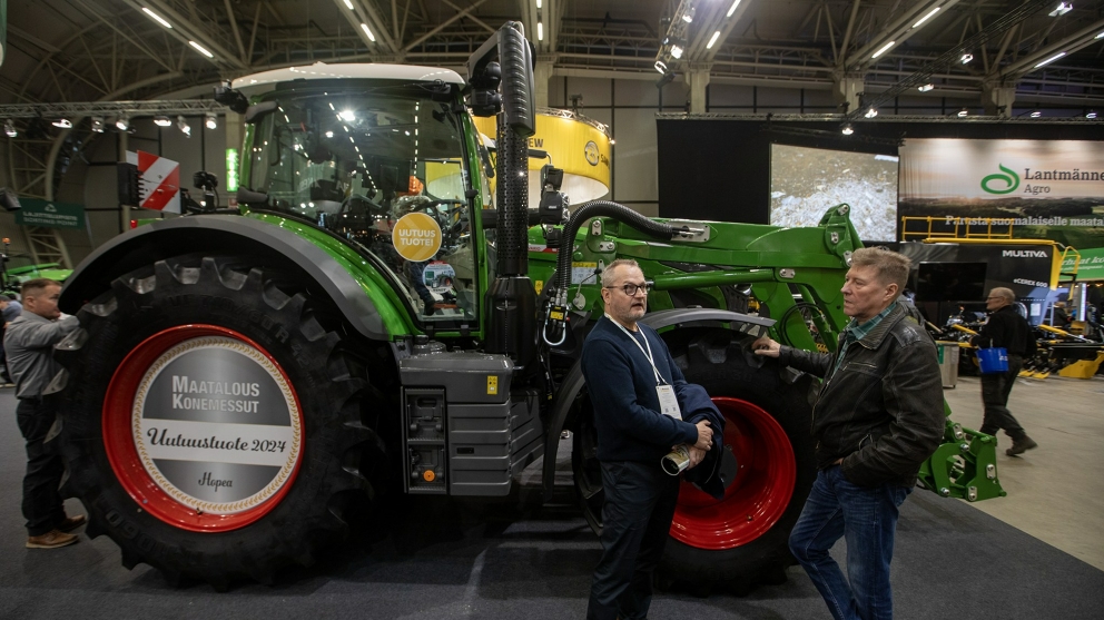 Trade fair visitors in front of the award-winning Fendt 600 Vario Two trade fair visitors standing in front of the award-winning Fendt 600 Vario and chatting