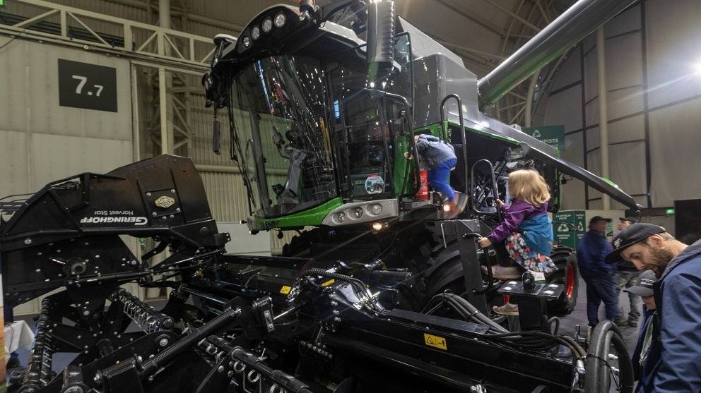 Children climb onto the Fendt straw walker combine harvester Children climb a ladder into the cab of the Fendt straw walker combine harvester