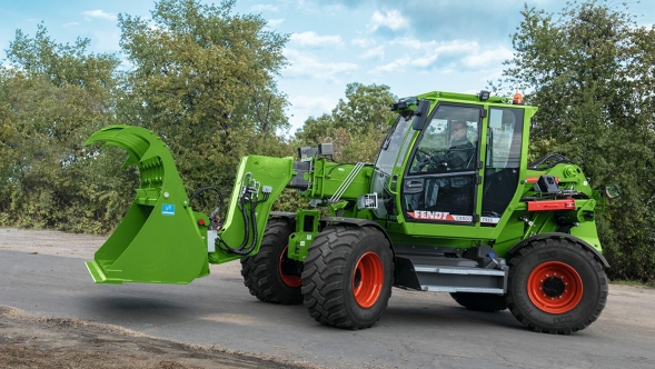 Fendt Cargo T955 with silage bucket A farmer standing in the yard with an open silage bucket on a Fendt Cargo T955. Trees can be seen in the background.