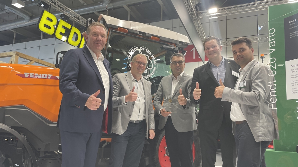 Christoph Gröblinghoff, Karsten Köhler, Roland Schmidt, Dr Dominic Esser and Philipp Schuchardt in front of an orange Fendt e100 Vario ve men: Christoph Gröblinghoff, Karsten Köhler, Roland Schmidt, Dr Dominic Esser and Philipp Schuchardt (all Fendt) in front of an orange Fendt e100 Vario with thumbs up and the TotY 2025 award