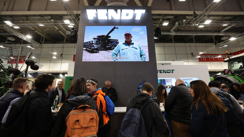 Visitors standing at the Fendt exhibition stand in front of a screen showing videos from Fendt