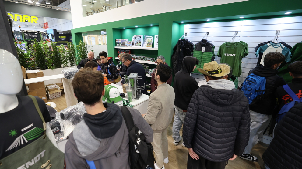 Visitors and fans in the Fendt merchandise area buy Fendt clothing and caps