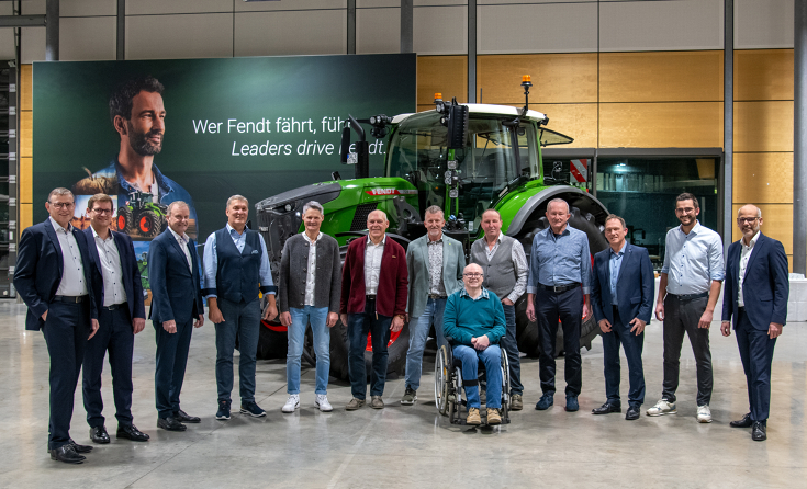 Fendt employees celebrating 40 years with the company and Fendt management in front of a Fendt tractor