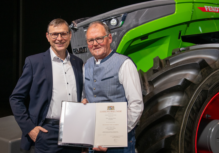 Walter Wagner and Michael Horn in front of a Fendt tractor with Michael Horn's certificate of honour