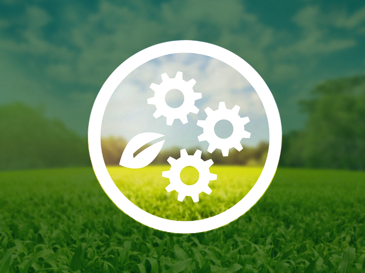 Three white cogwheels and a white leaf are inside a circle. The background shows a green forest meadow under a blue sky, which is darkened outside the circle by a dark green, partially transparent layer.