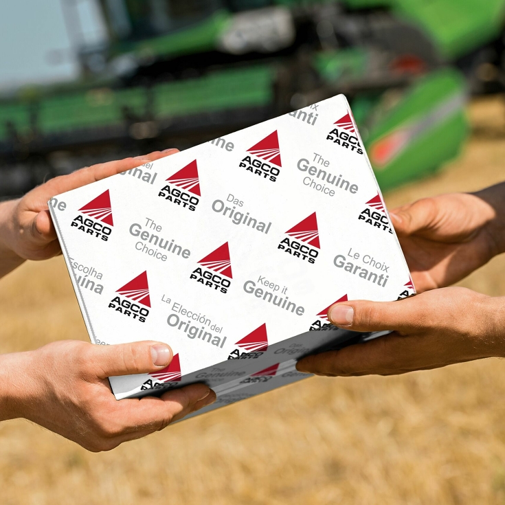 Handover of an AGCO Parts package in the field.