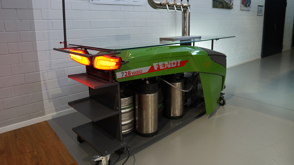 Fendt dispensing station (diagonally from behind) with Fendt logo, glass shelf, glass racks and front and rear lights switched on.