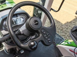 Close-up of the exclusive single-spoke steering wheel in the Fendt 900 Vario MT with integrated controls for the audio system, surrounded by a light-coloured interior