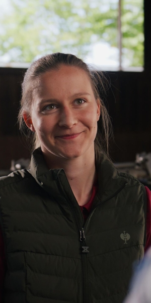 Young farmer A young farmer standing in the stable looking at her father who is smiling
