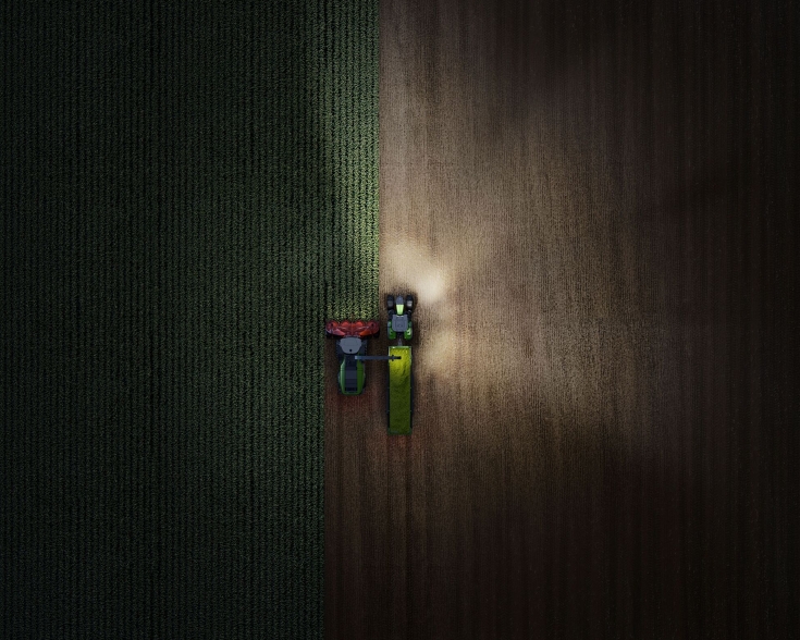 Drone image of a Fendt 800 Vario at night with lights on – right.