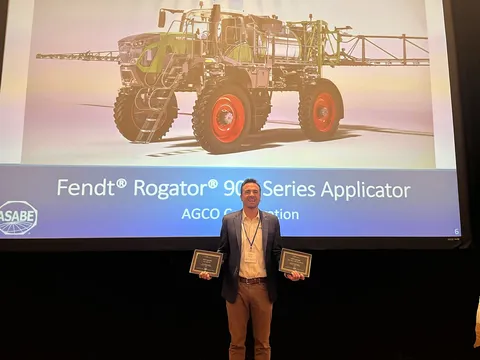 Conor Birgin davanti a una proiezione del pluripremiato Fendt Rogator 900 con due certificati in mano