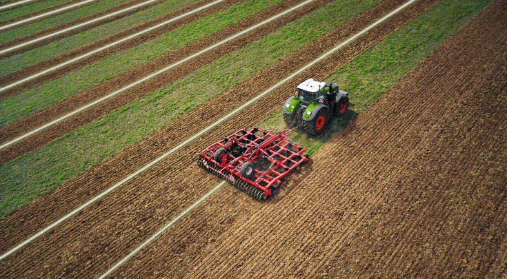 Il Fendt 1000 Vario lavora il terreno con un coltivatore.